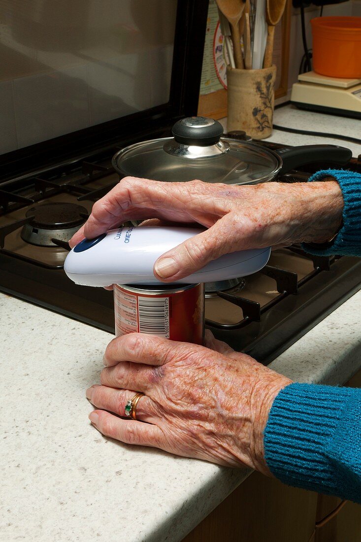 Elderly woman opening a tin