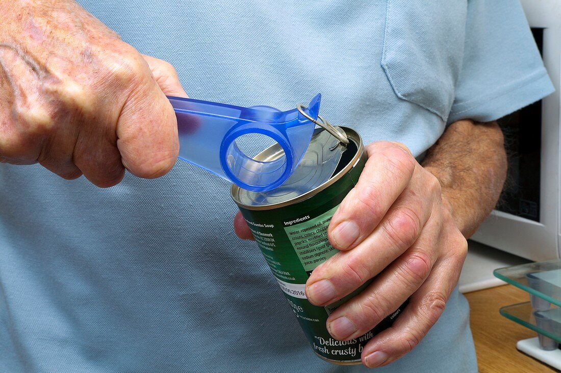 Elderly man opening a tin
