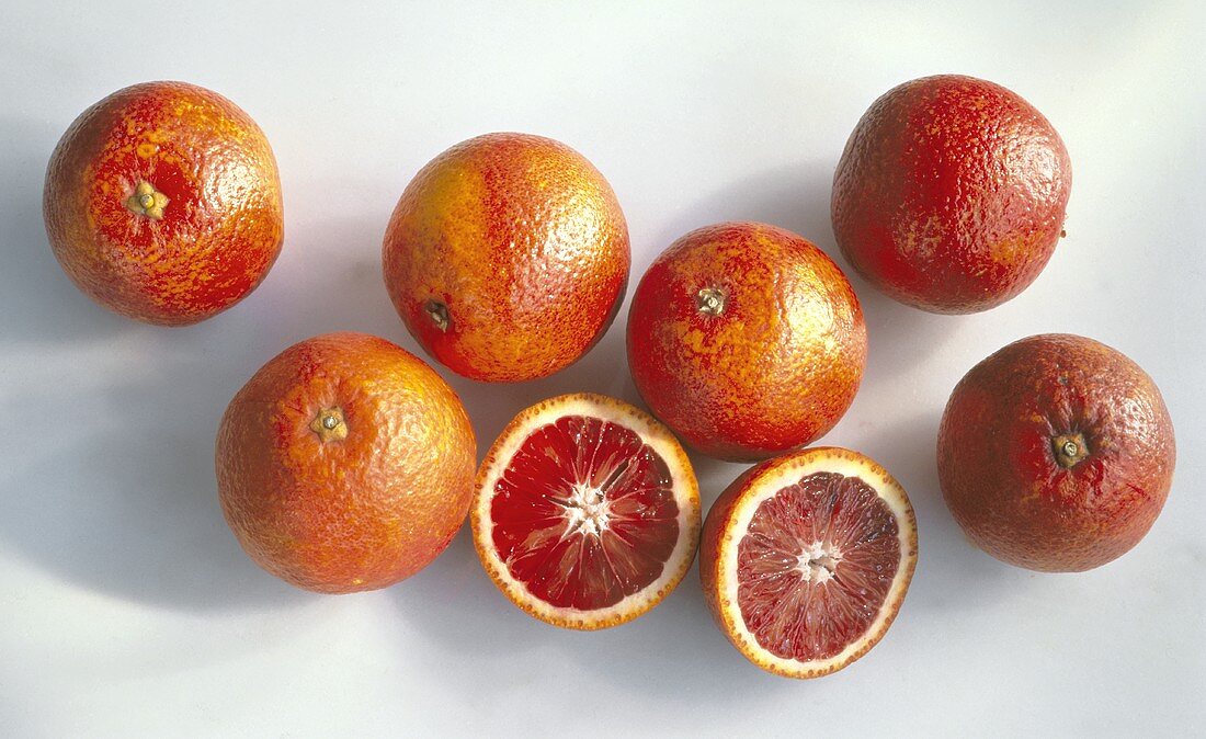 Several Blood Oranges; One Cut in Half