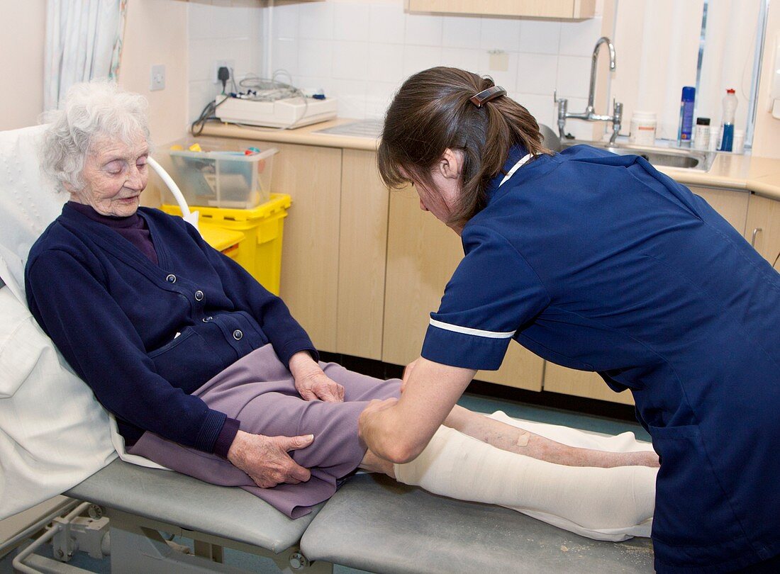 Nurse dressing a patient's leg