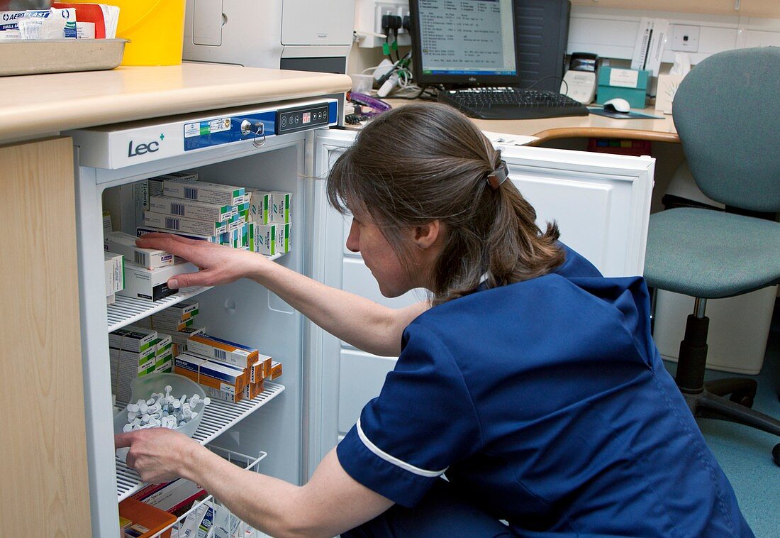 Practice nurse checking vaccine fridge