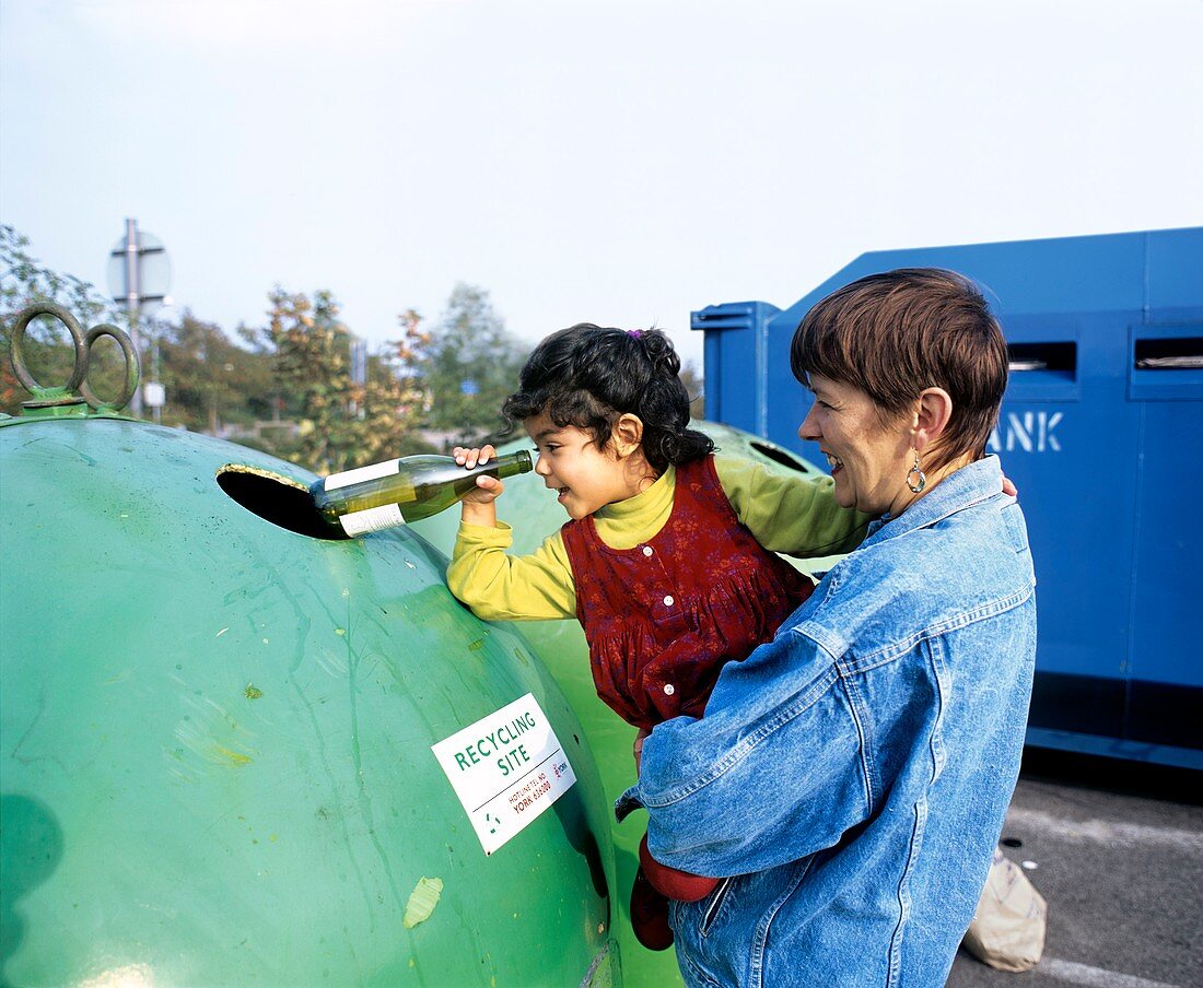Mother and child recycle a glass bottle