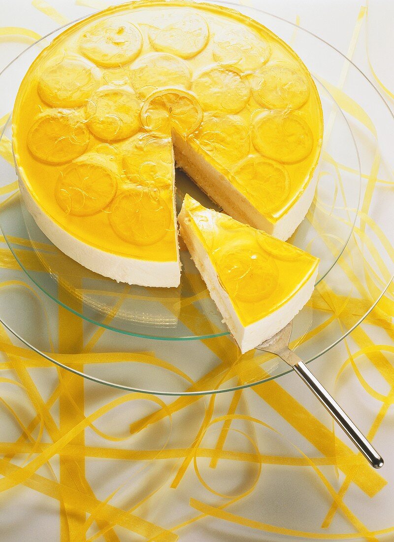 Cheesecake with lemon icing; & piece on cake slice