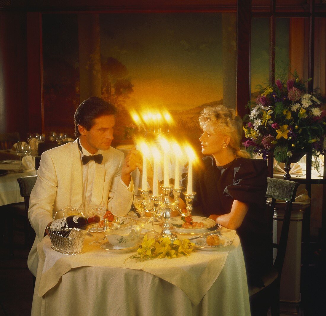 A Man and Woman Having Dinner by Candle Light