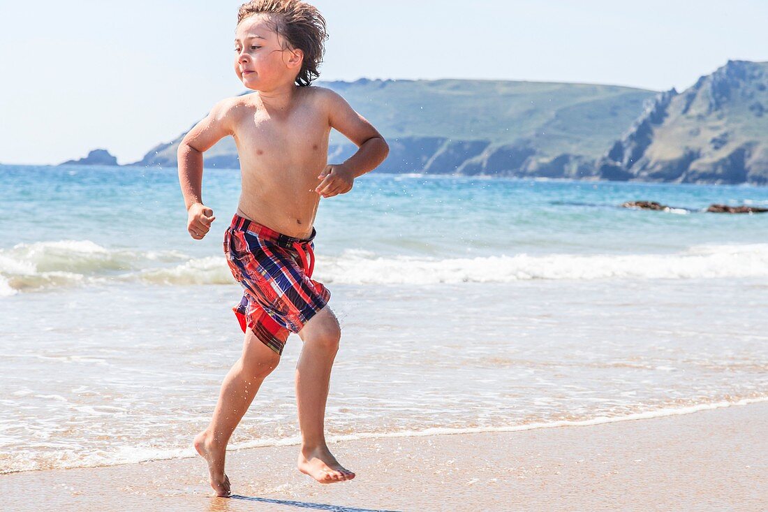 Young boy running on the beach