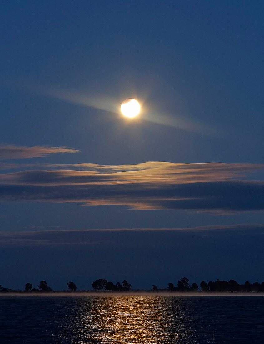 Partial lunar eclipse over coastal lagoon