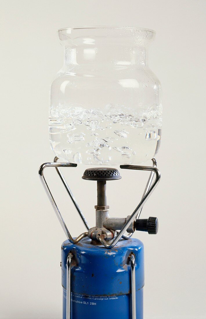 Water boiling in glass beaker on top