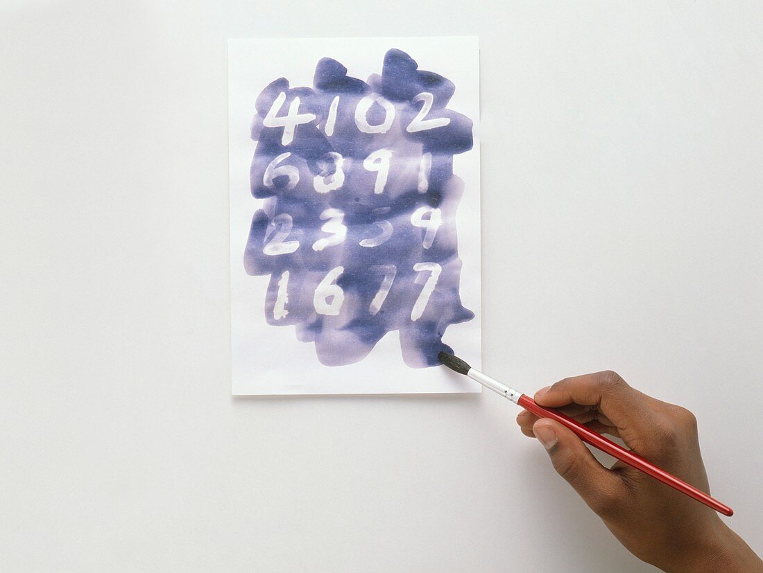 Child using paintbrush and blue ink
