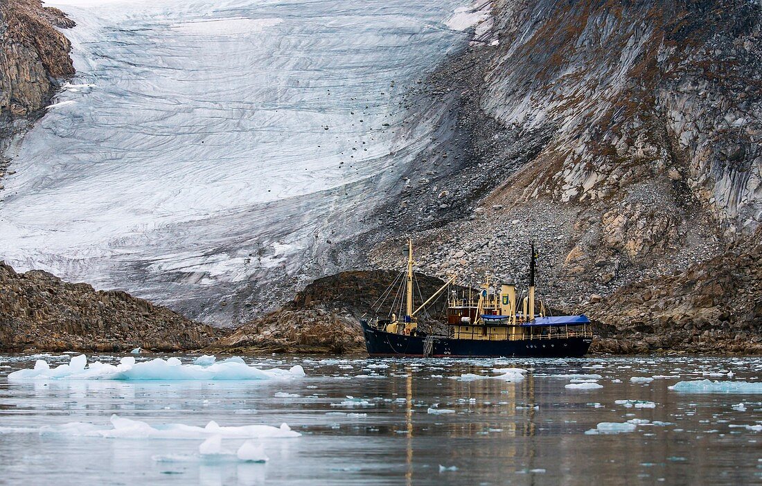Tourist boat dwarfed by glacier terminus
