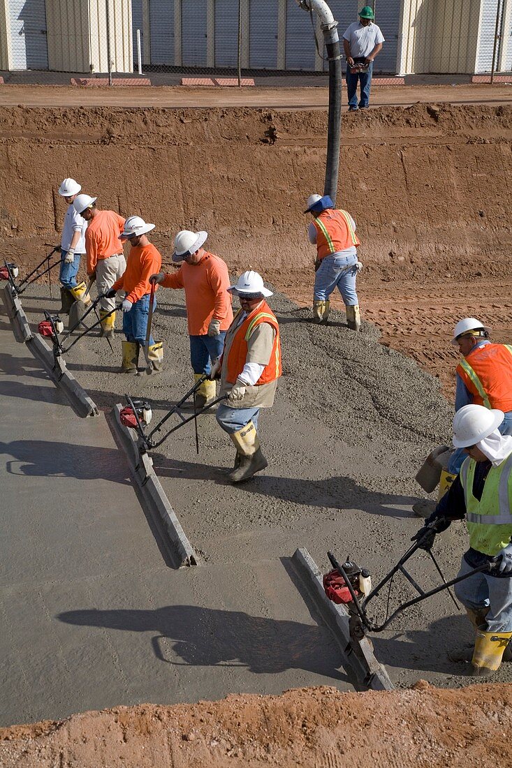 Workers lining a canal with concrete