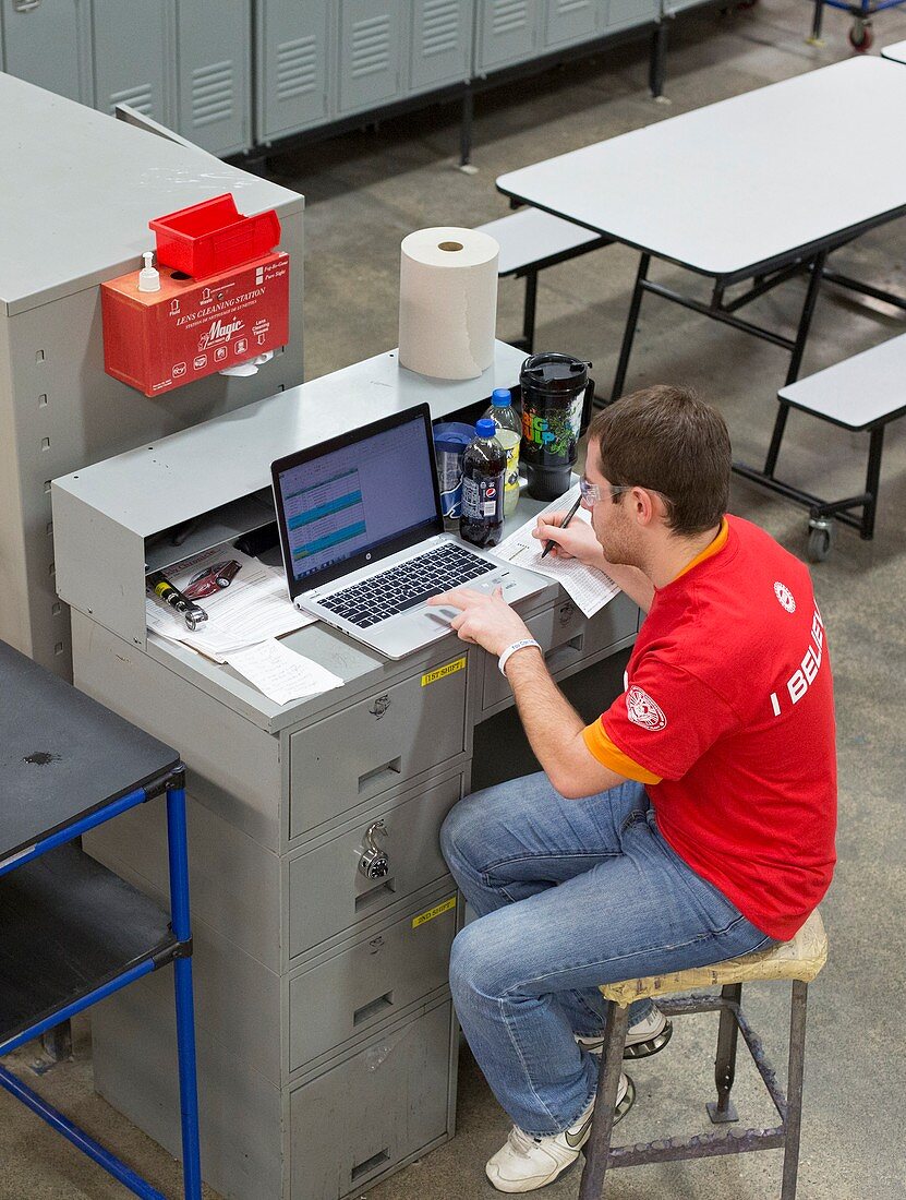 Worker using laptop in a factory