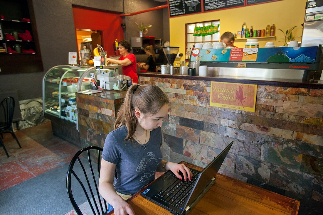 Girl using a laptop in a cafe