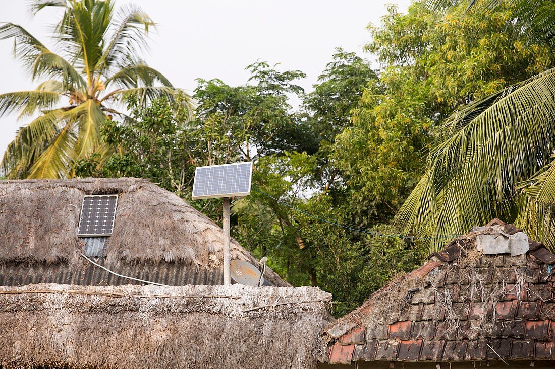 A mud hut with a small solar panel