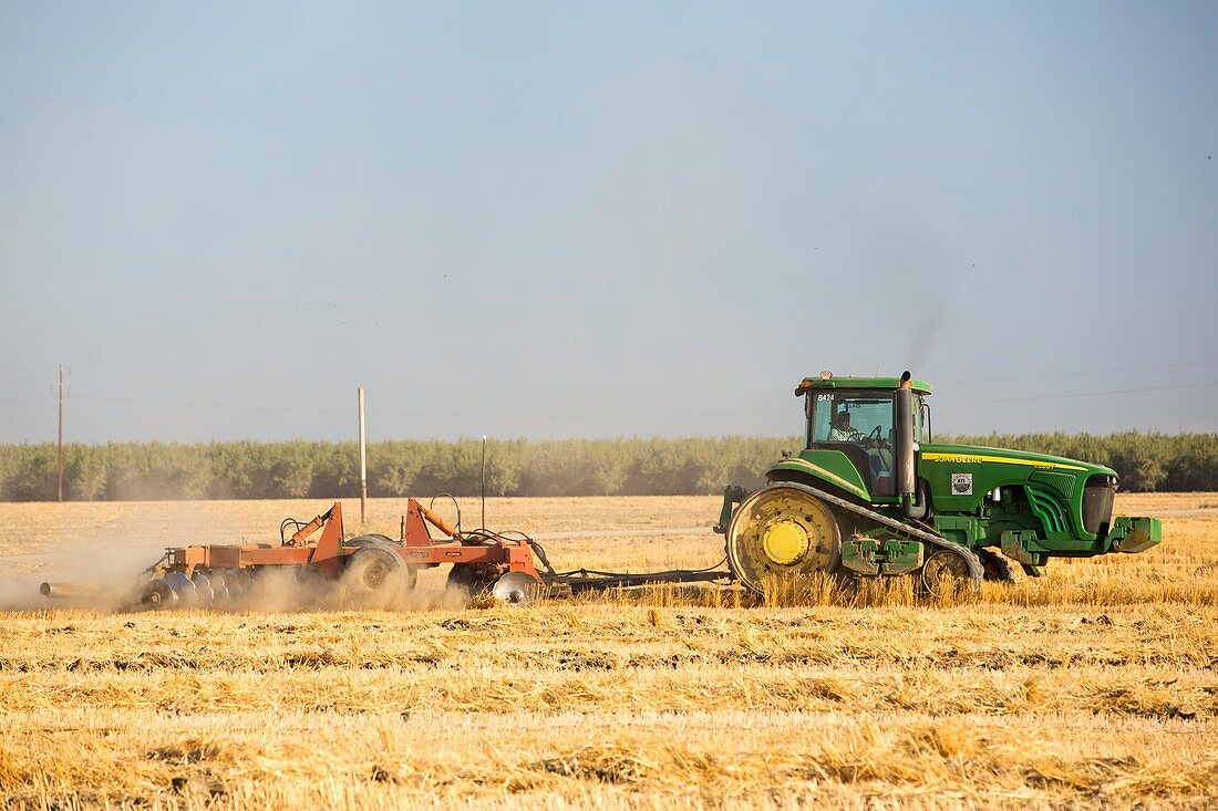 A farmer ploughs a field in Wasco