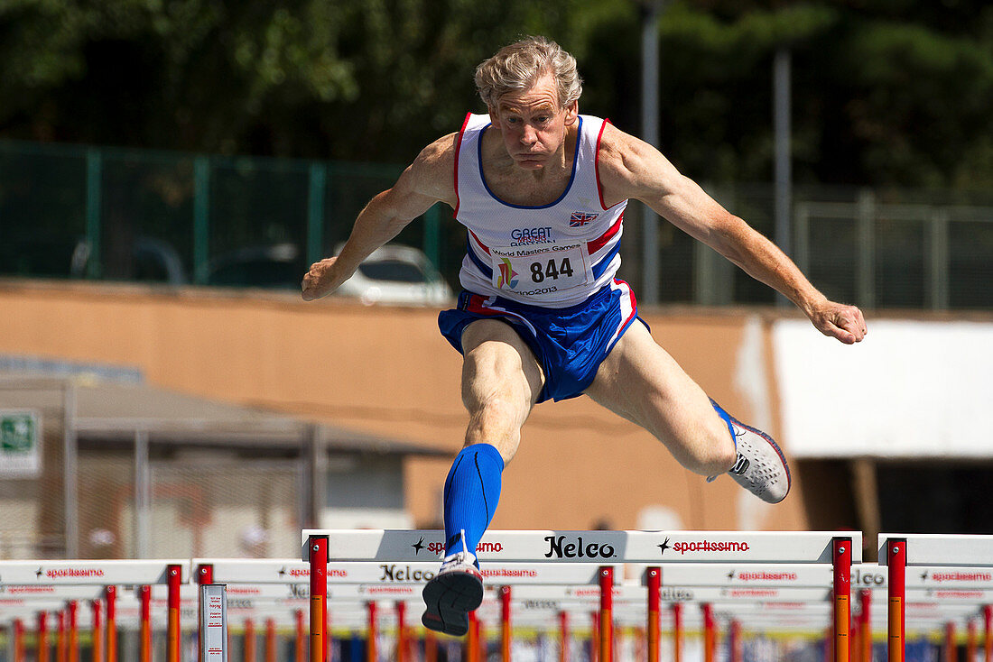 Masters British athlete clearing hurdle