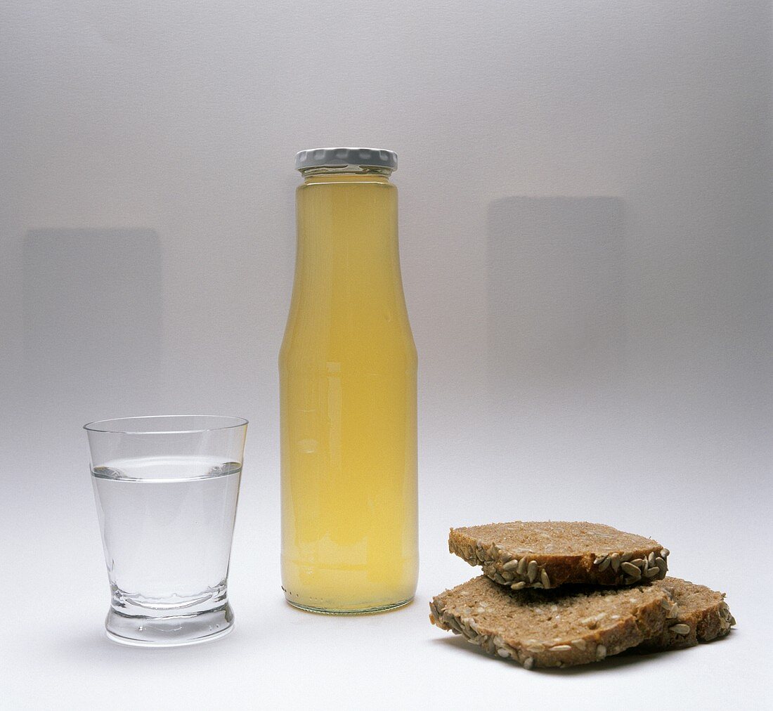 Glass of mineral water, bottle of bread drink & bread slices