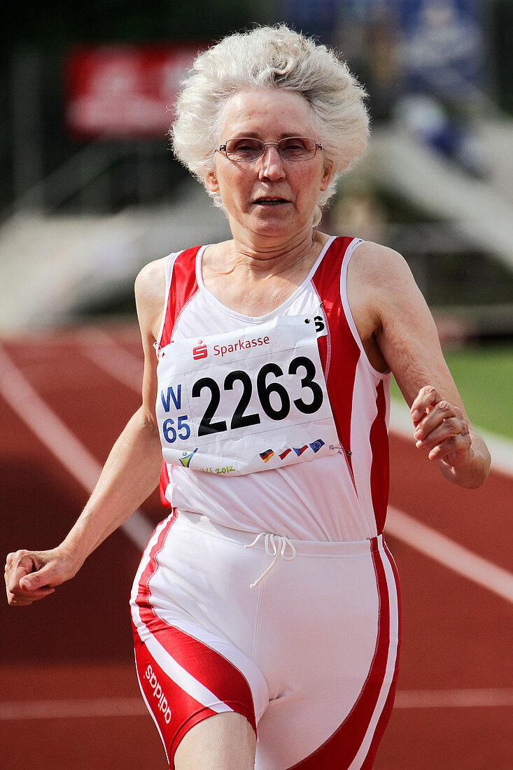 Older female athlete runs to camera
