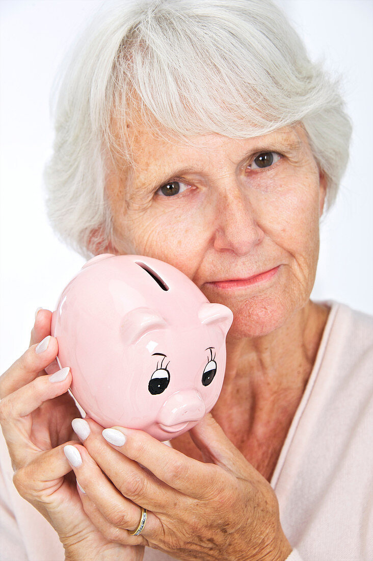 Elderly woman with a piggy bank