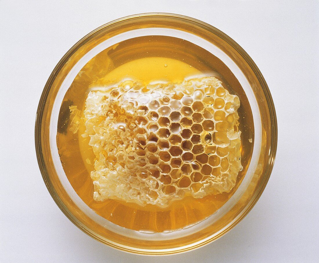 A small bowl of honey with honeycomb