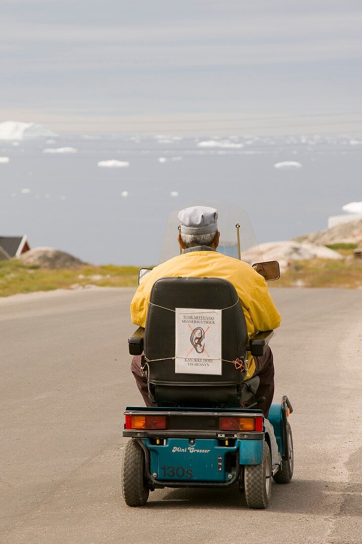 An Inuit man in a mobility scooter