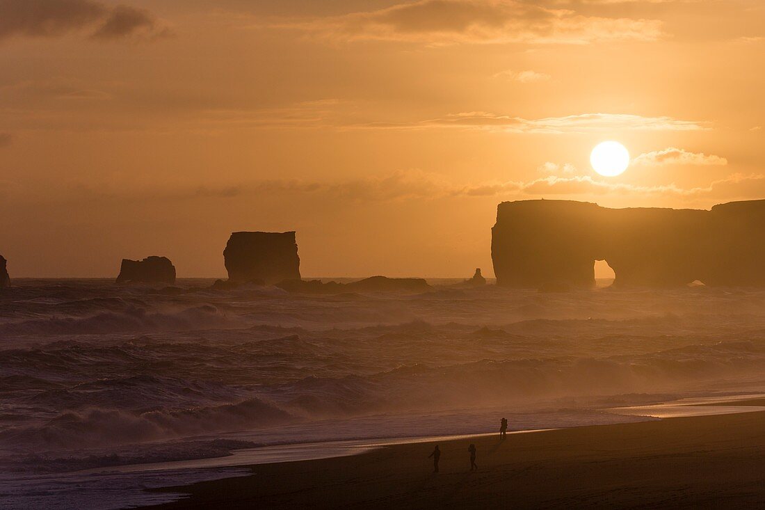 Sunset over arch and sea stacks