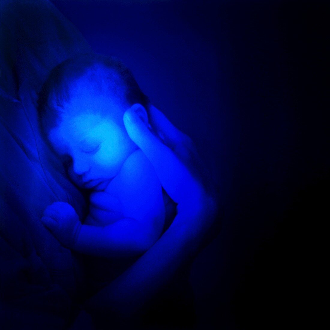 Sleeping baby under blue light