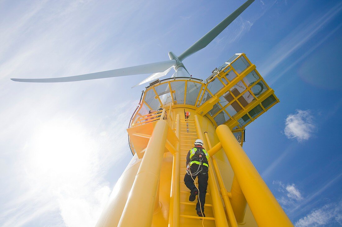 A worker climbs a turbine