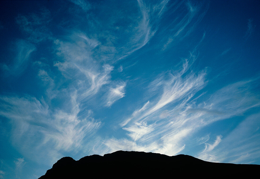 Cirrus clouds over mountain ridge