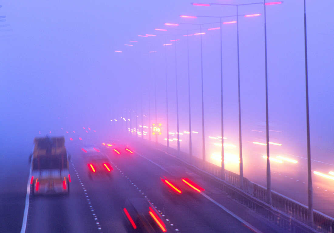 Vehicles driving through fog on a motorway