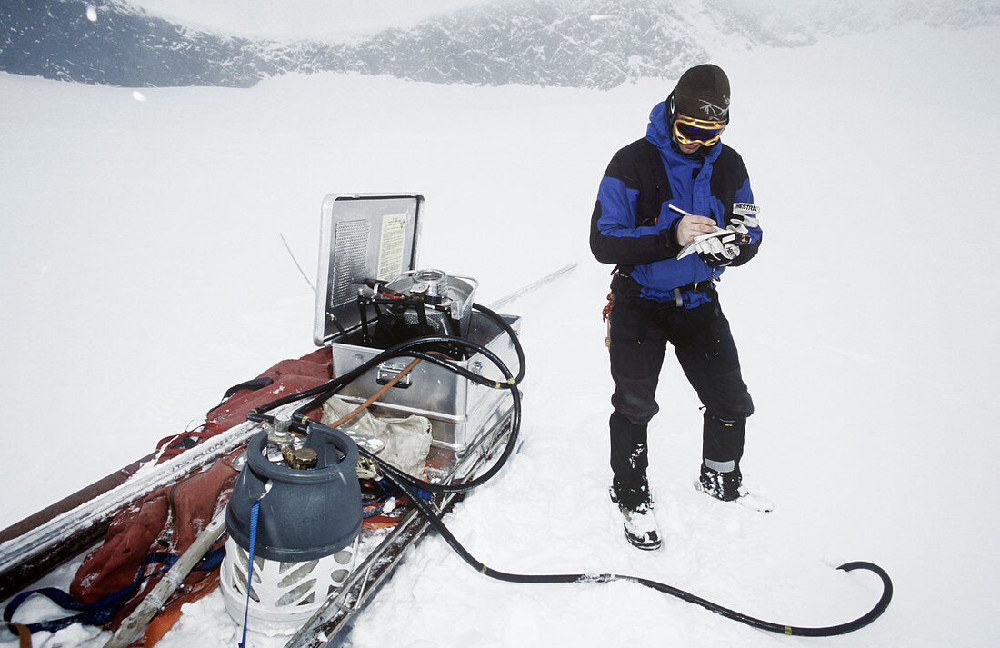 Glaciologist drilling on a glacier