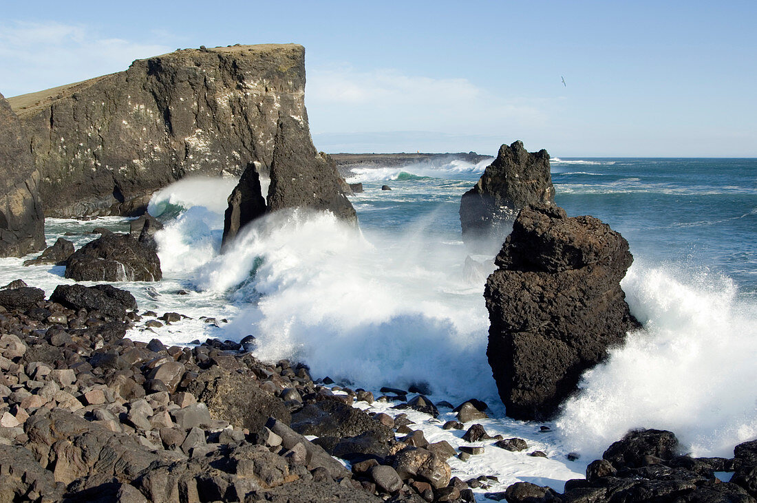 Waves crashing against basalt rocks
