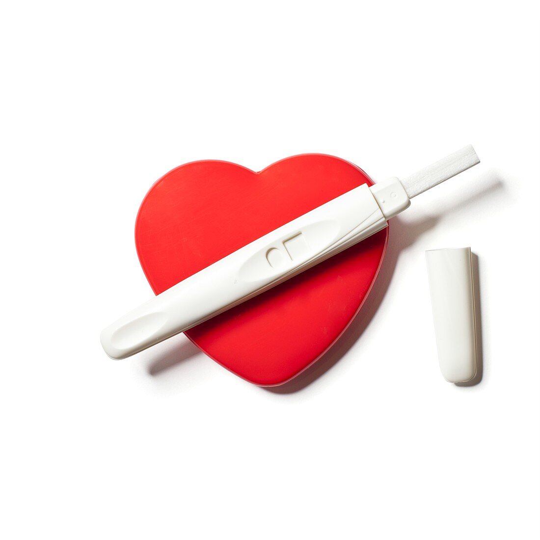 Pregnancy test on red heart