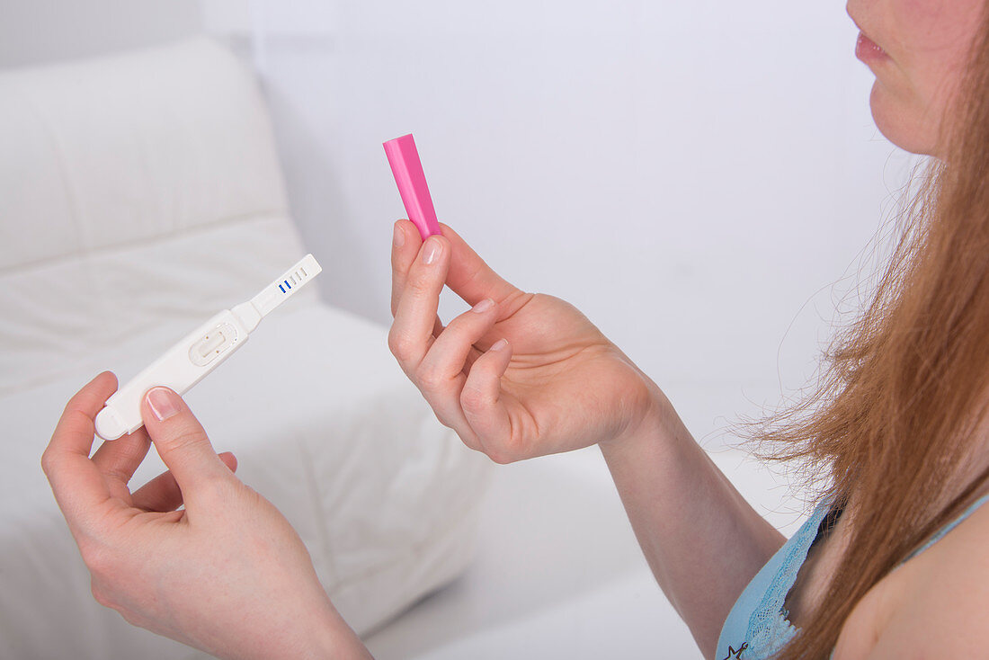 Young woman taking pregnancy test at home
