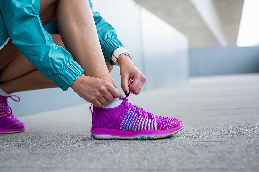 Woman tying laces on trainers