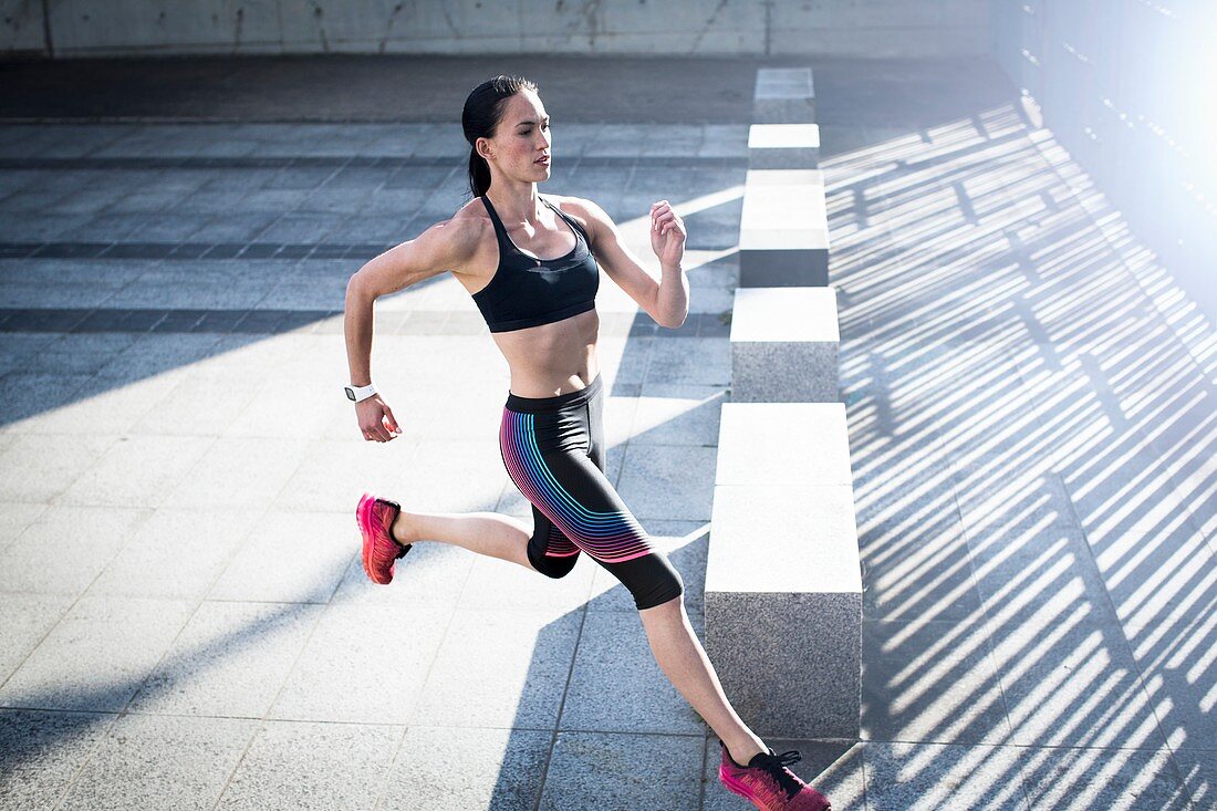 Woman running across concrete,high angle