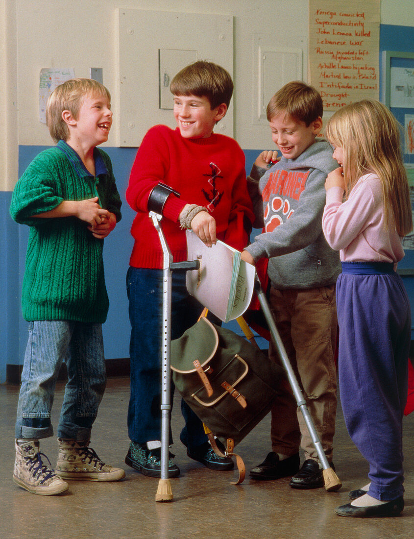Handicapped boy with crutches and his friends