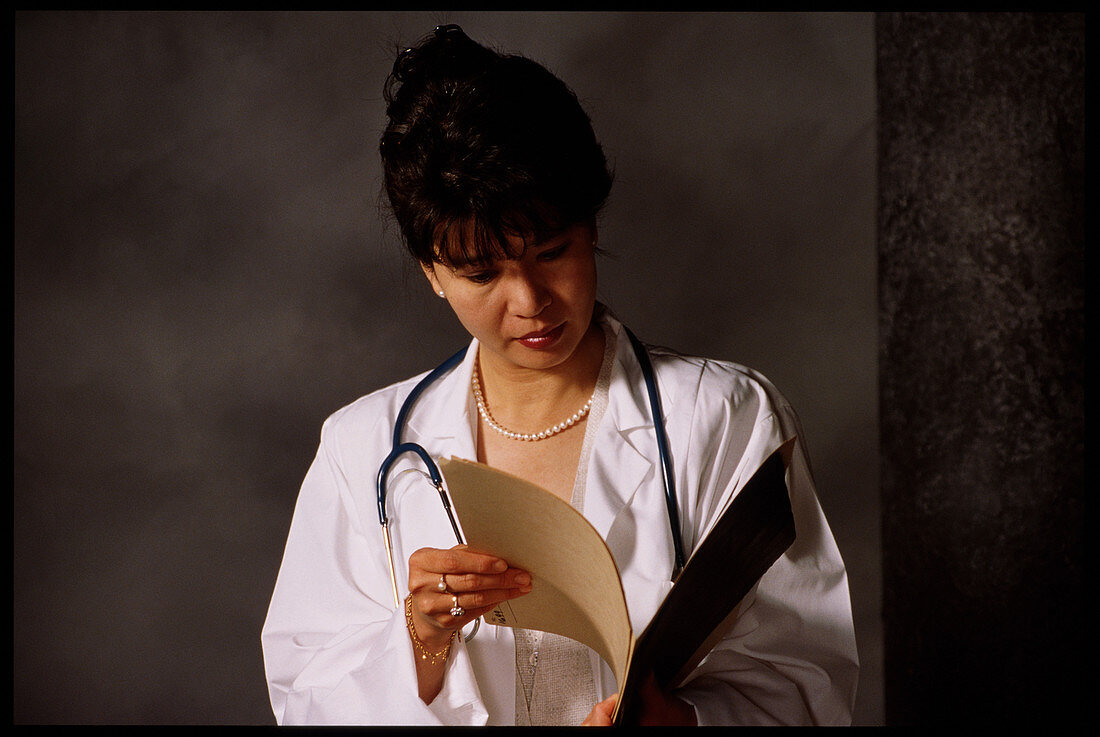 Female doctor studies medical records