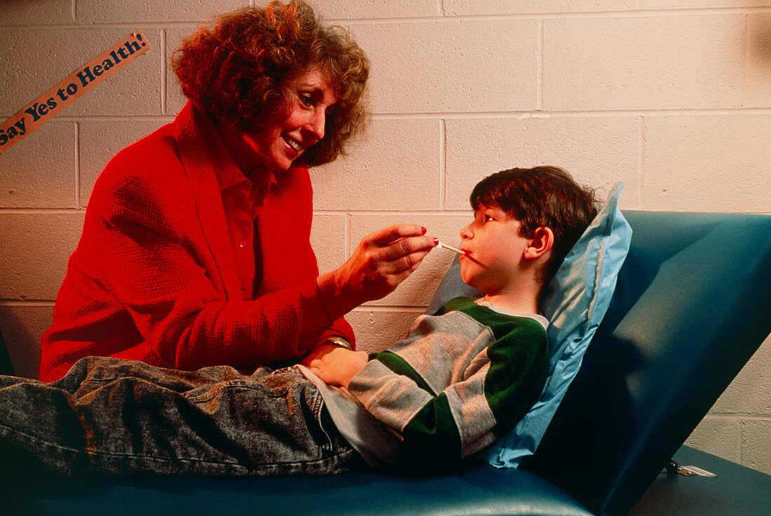 School nurse taking boy's temperature