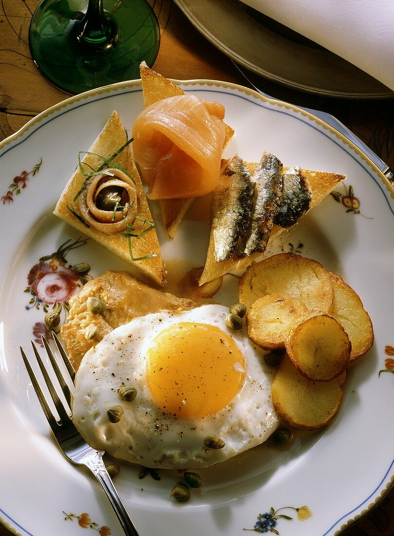Veal with a Fried Egg and Potatoes and Raw Fish