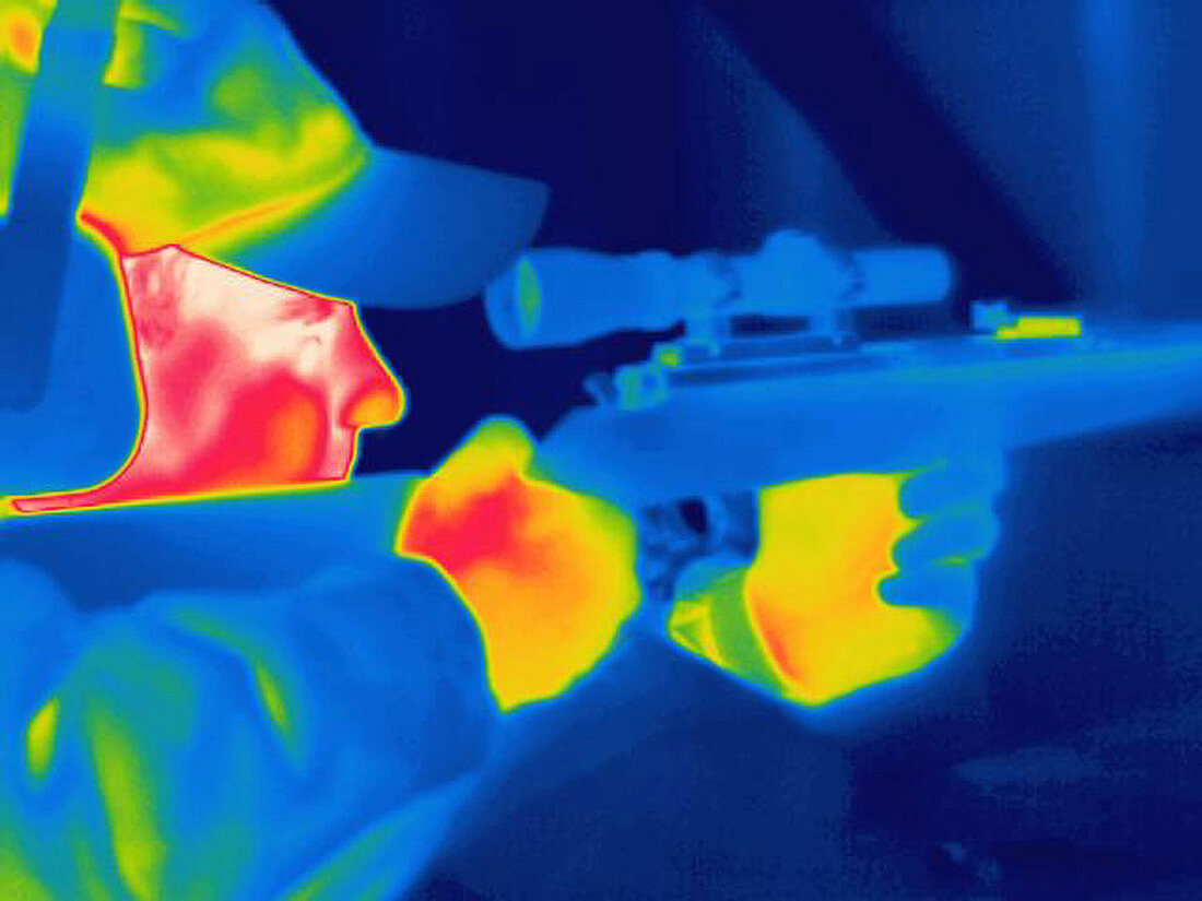 A thermogram of a man holding a rifle