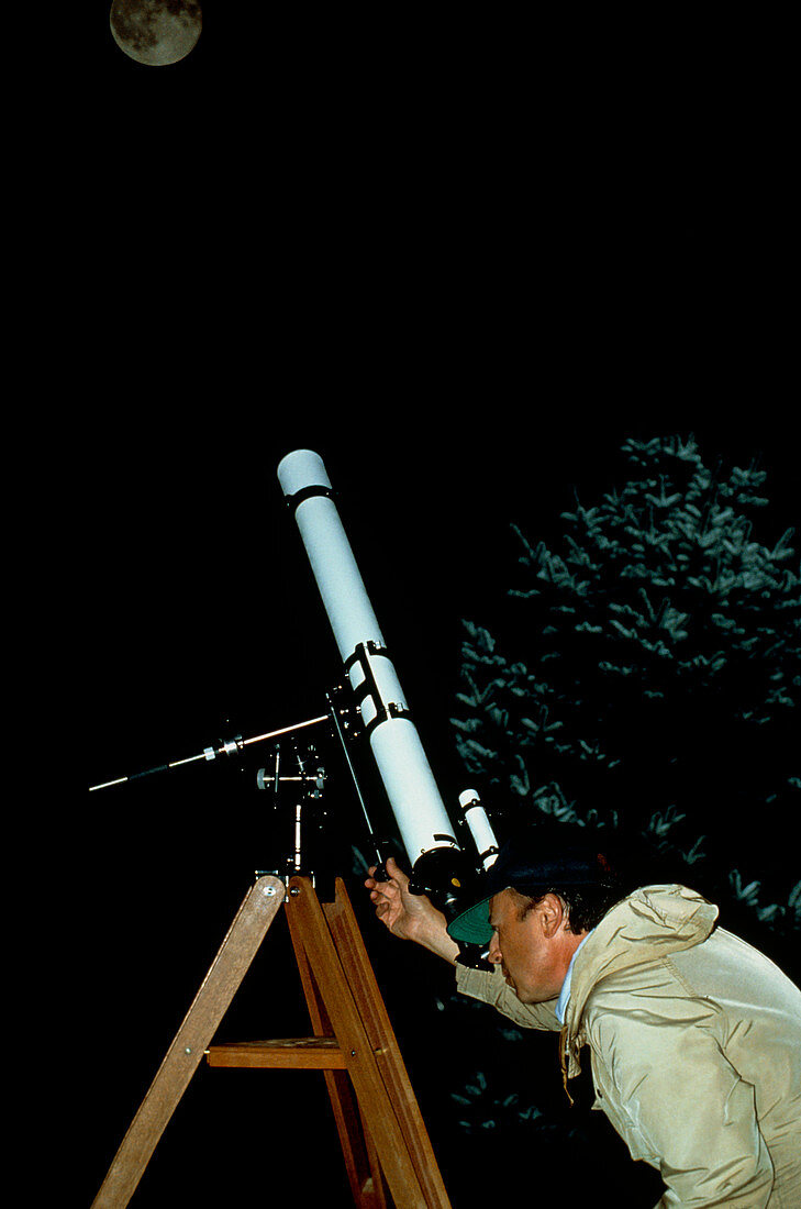 Amateur astronomer observing moon with telescope