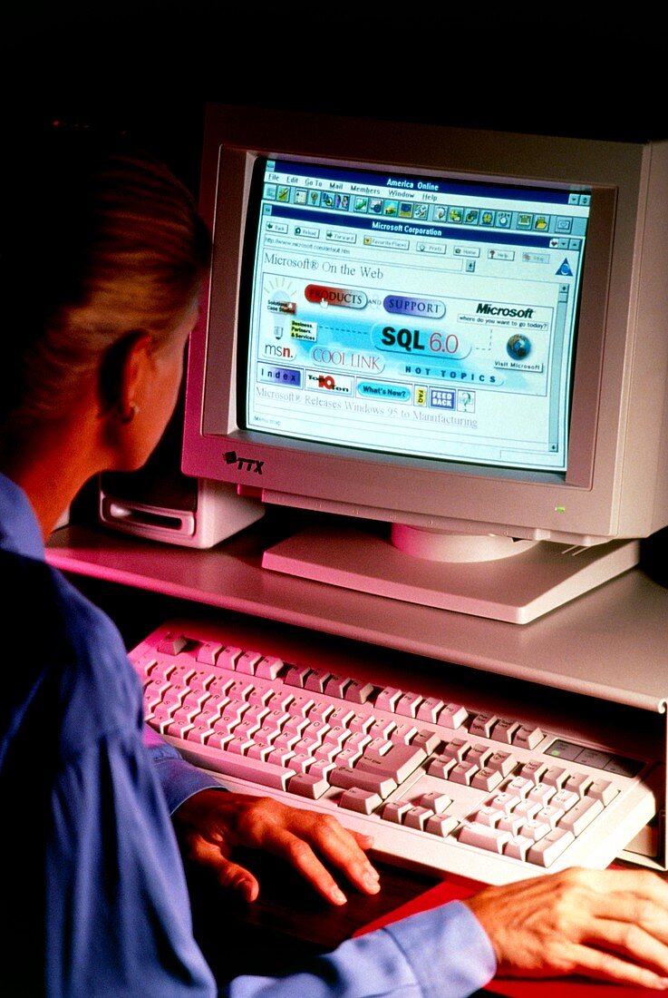 Woman at computer accesses Microsoft on internet