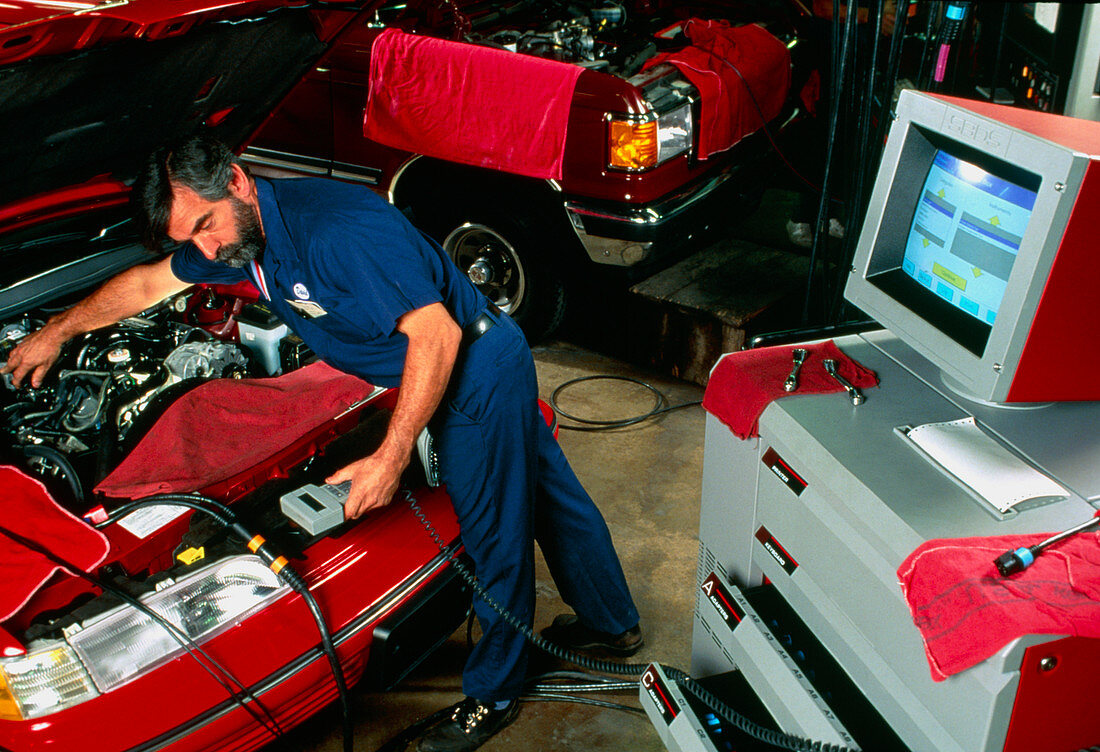 A mechanic testing a car engine with a computer