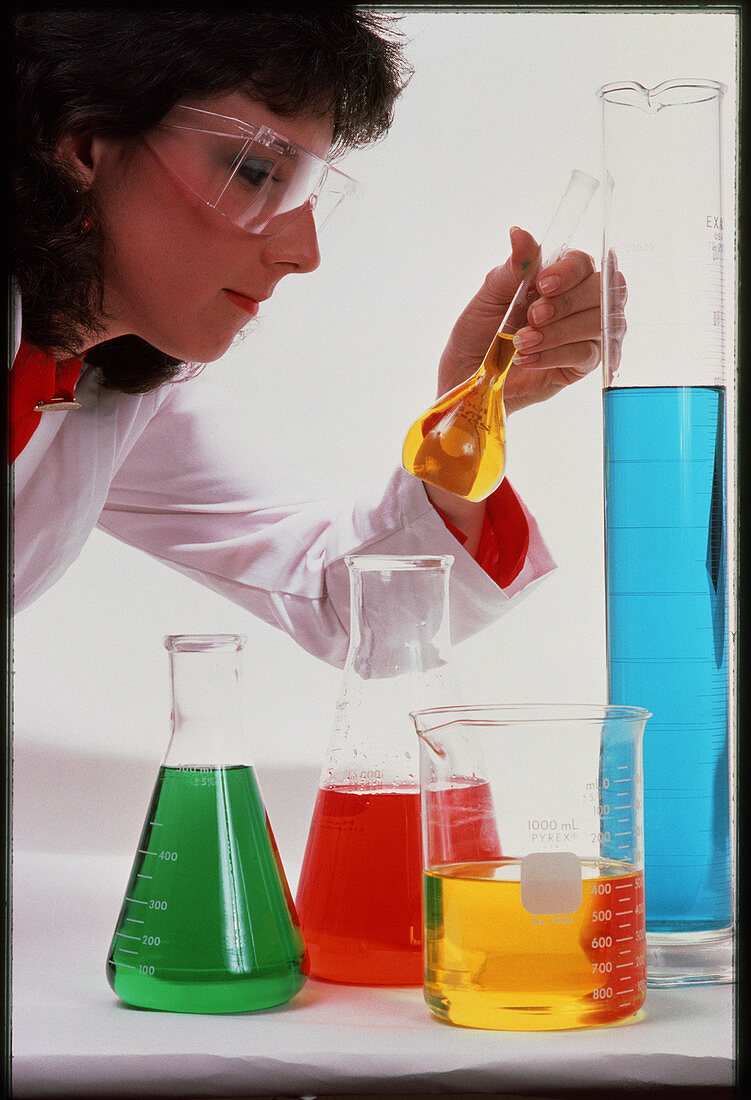 Chemist examines solution in laboratory glassware