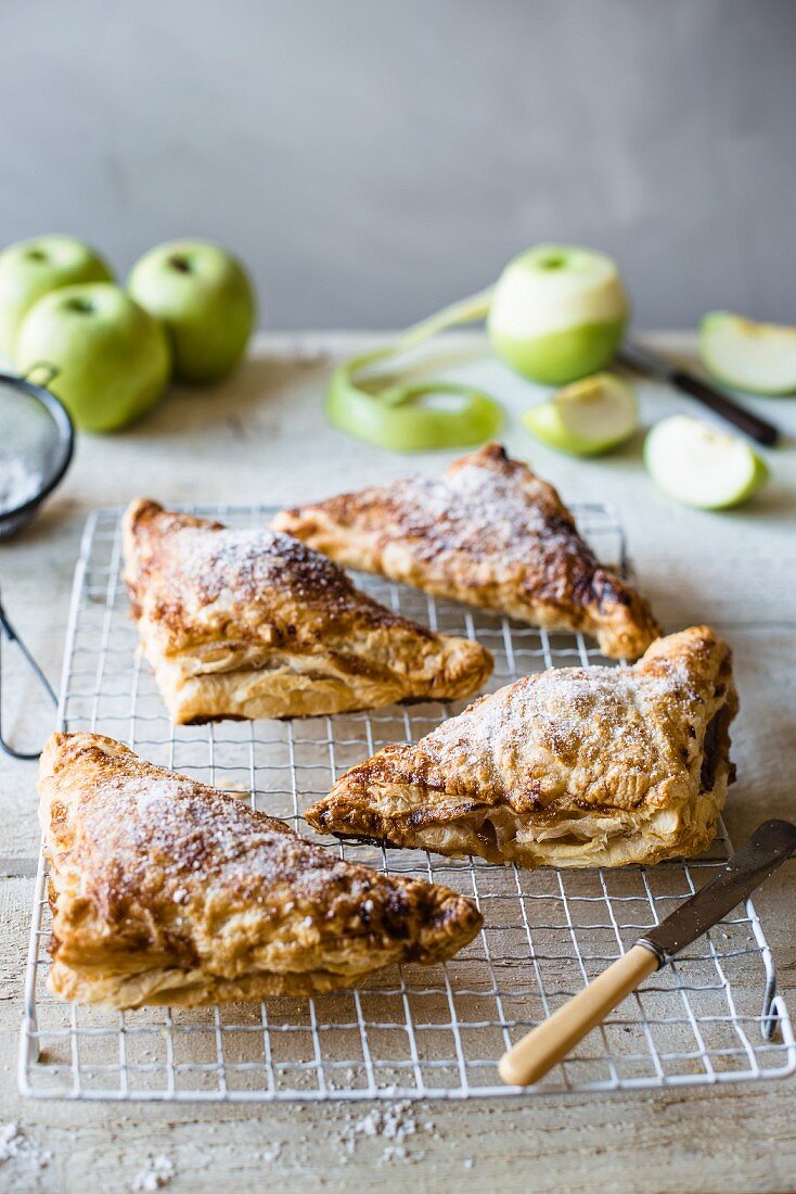 Freshly baked apple turnovers on a cooling tray