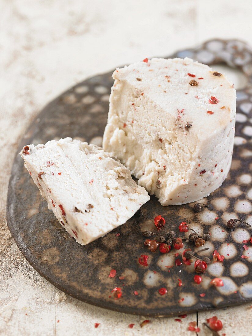 Vegan macadamia nut cheese with red and black peppercorns