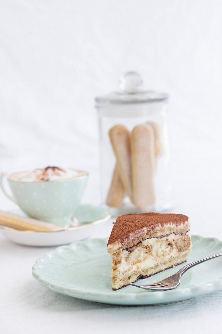 A slice of tiramisu cake and a cappuccino