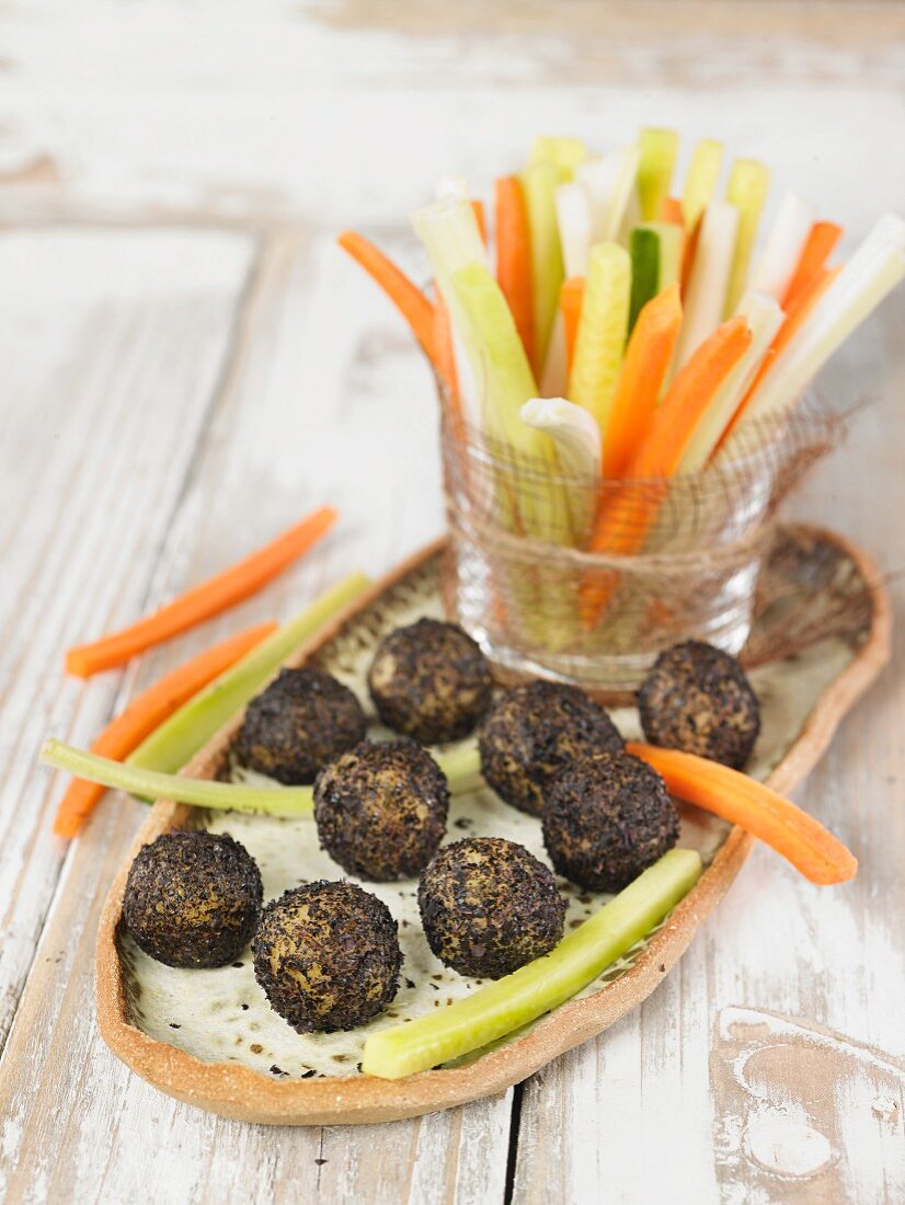 Vegan macadamia nut and cashew nut cheese balls rolled in nori and served with vegetable sticks