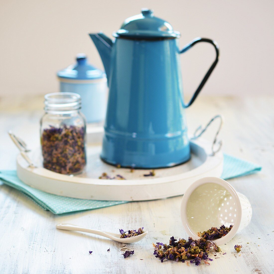 Mallow tea in a teapot with a glass jar and tea sieve