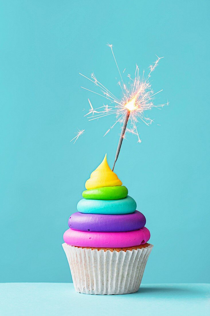 Brightly colored cupcake decorated with a sparkler